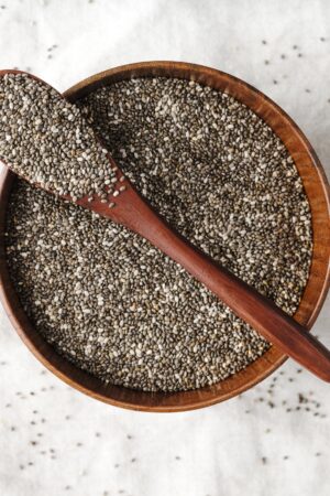 A spoonful of premium chia seeds with wooden background – healthy superfood by Pyazon