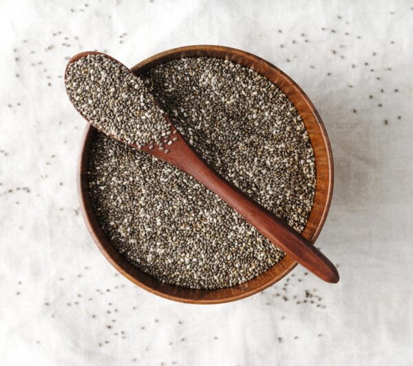 A spoonful of premium chia seeds with wooden background – healthy superfood by Pyazon
