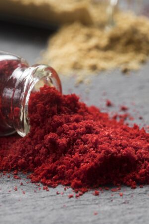 Paprika powder in a bowl with wooden spoon and scattered red pepper flakes – Pyazon spice collection