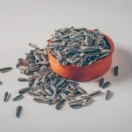 Roasted sunflower seeds in a ceramic bowl, sprinkled with whole seeds